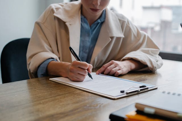 Cropped woman filling out a resume Cropped woman filling out a resume