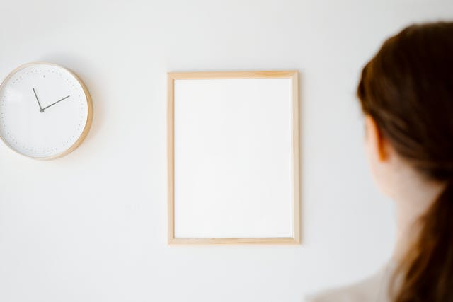 Woman looking at a clock and board on the wall Woman looking at a clock and board on the wall