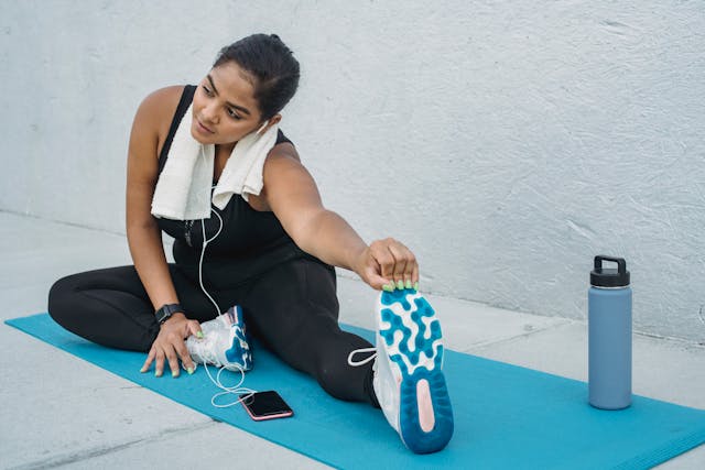 Woman stretching on a yoga mat in exercise close Woman stretching on a yoga mat in exercise close