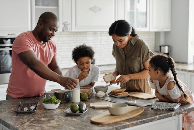 Family of four making breakfast in the kitchen Family of four making breakfast in the kitchen