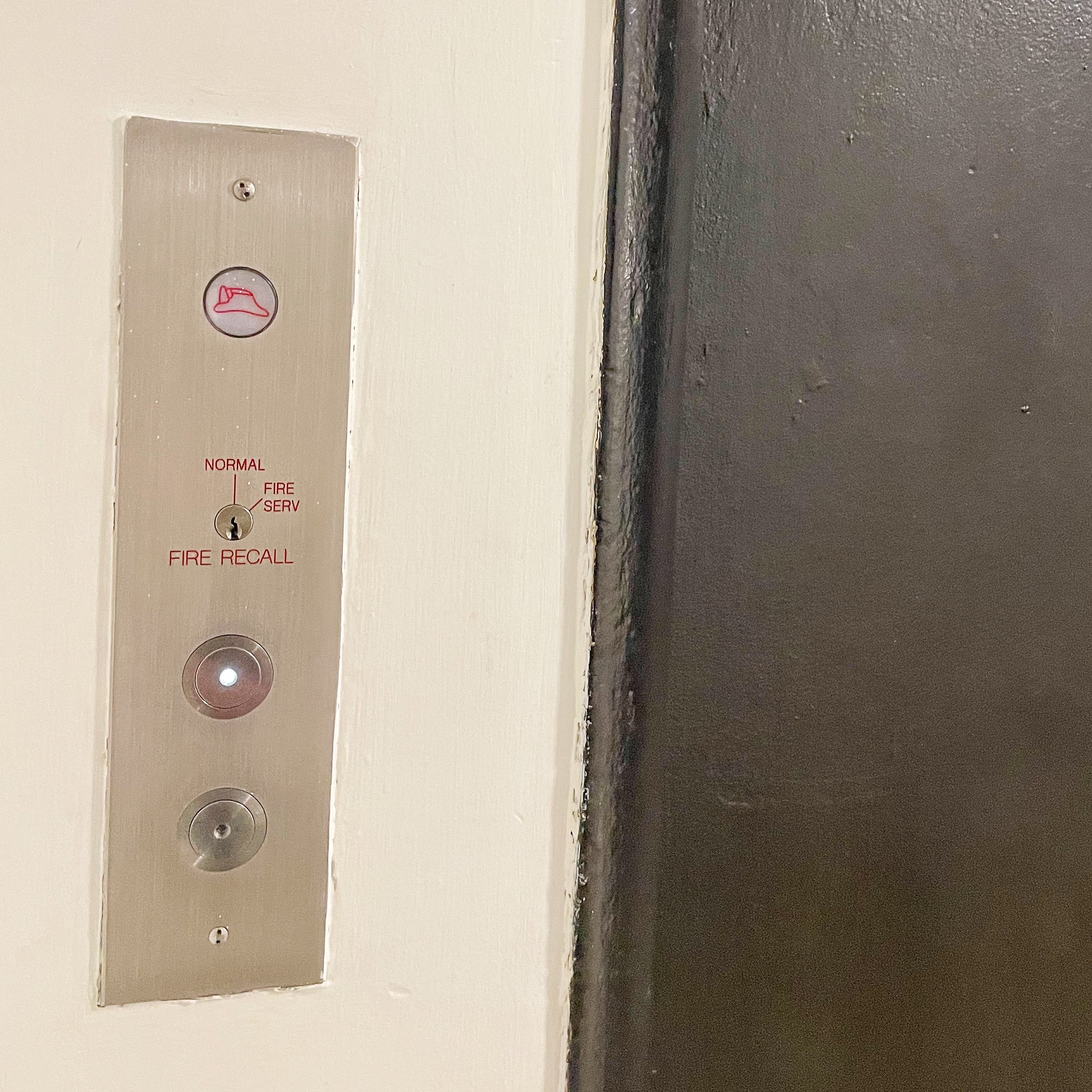 A metal plaque with 2 elevator buttons.