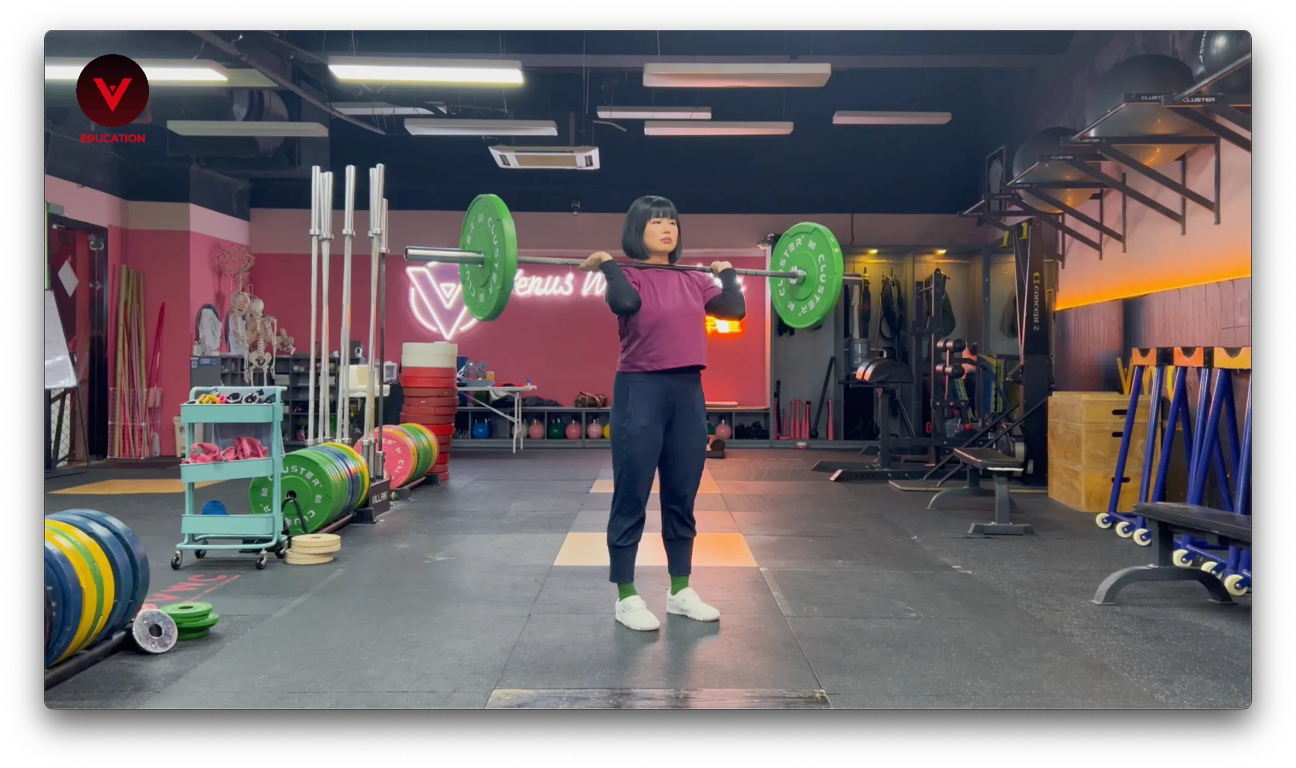 Weightlifting coach demonstrating the catching phase of the clean at Venus Weightlifting gym, holding the barbell in the front rack position after a successful lift. Weightlifting coach demonstrating the catching phase of the clean at Venus Weightlifting gym, holding the barbell in the front rack position after a successful lift.