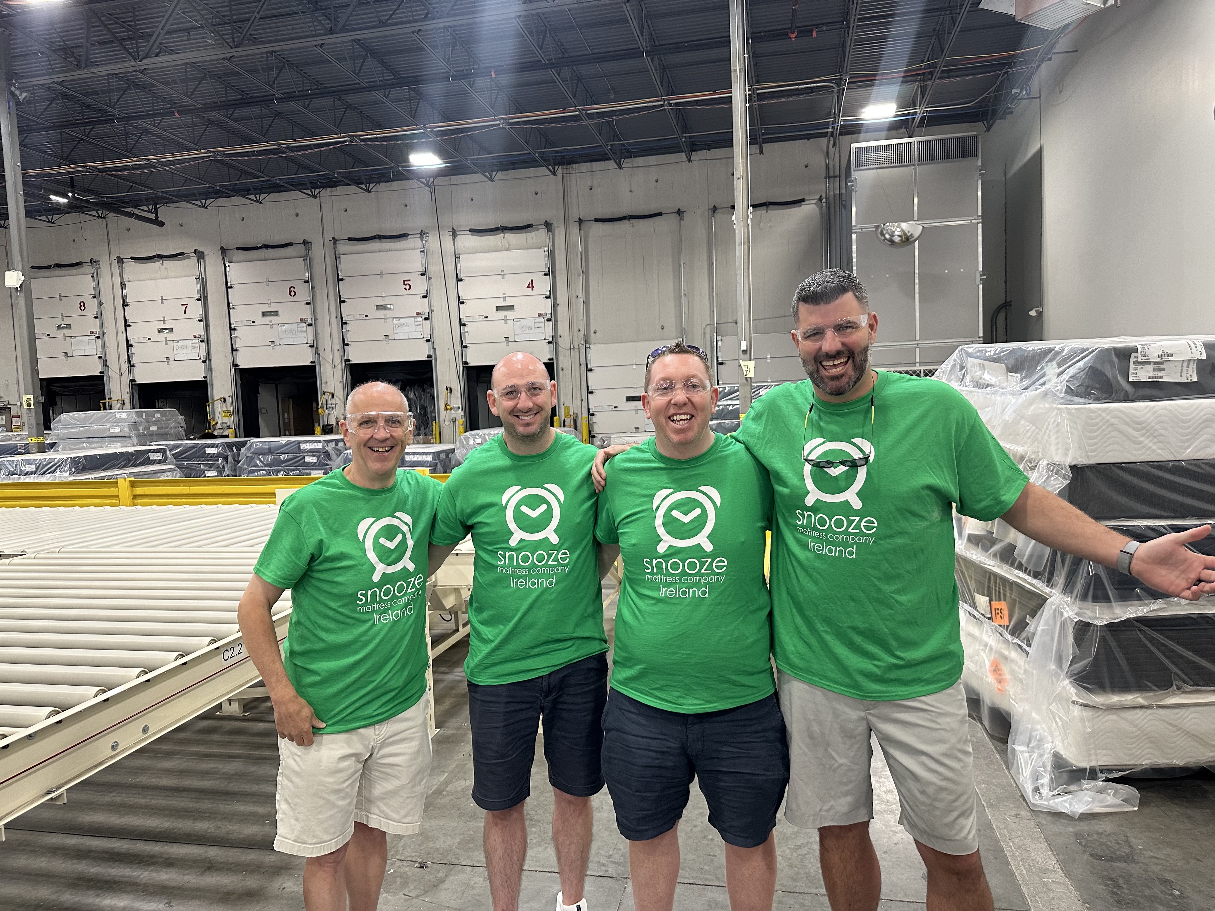 Matt Smith, Founder and CEO of Snooze Mattress Co. and Joe Paviglianti, Chief Success Officer of Snooze Mattress Co., stand with John Griffin and Kenneth Sexton, of Cork, Ireland, at the SSB facility in Denver, CO.