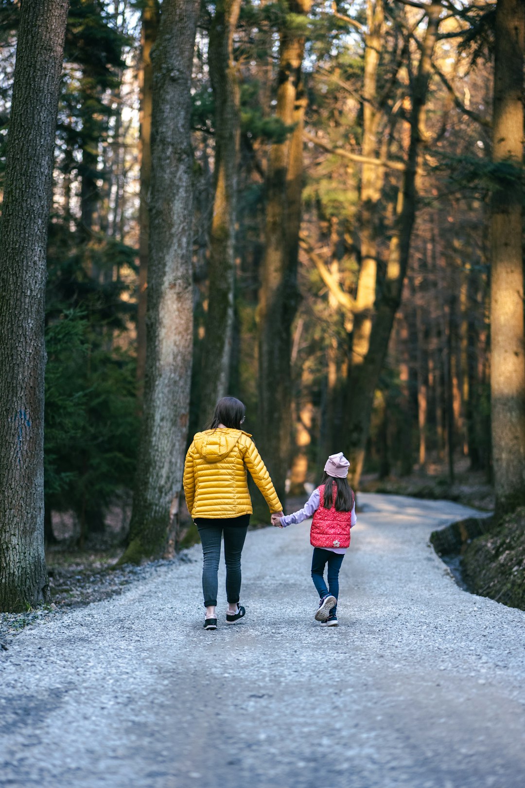 child walking with adult in woods