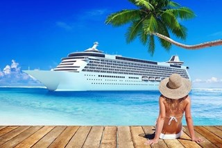 Cruise ship in the background with woman in sun hat sitting on the dock in the foreground Cruise ship in the background with woman in sun hat sitting on the dock in the foreground