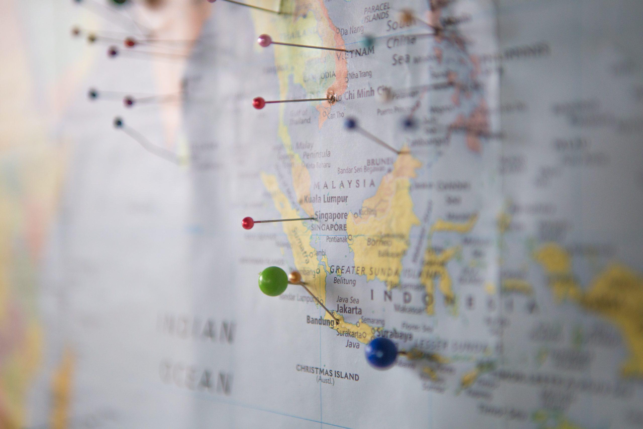 World map with multi colored push pins 