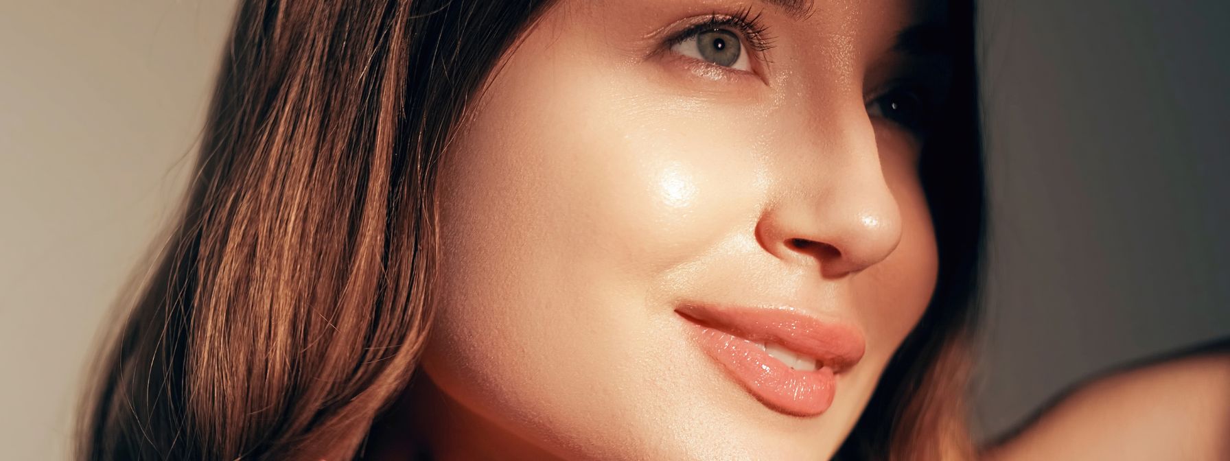 Close-up of a woman's glowing, smooth skin, highlighting the radiant results achievable through dermaplaning and a well-rounded skincare routine.