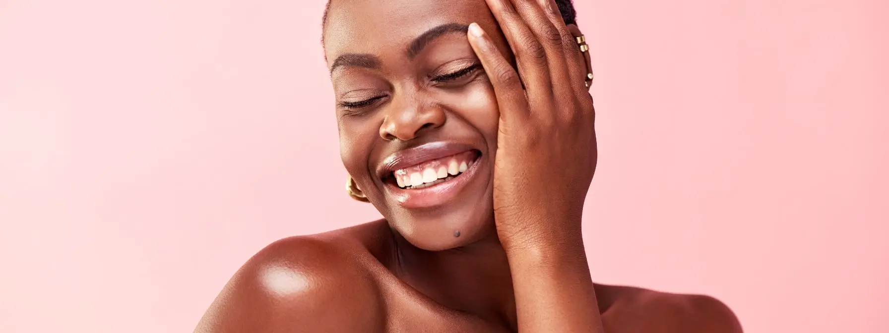 Joyful woman with glowing, even-toned skin smiling with her eyes closed, showcasing the radiant results of a chemical peel treatment in Greenville, SC.
