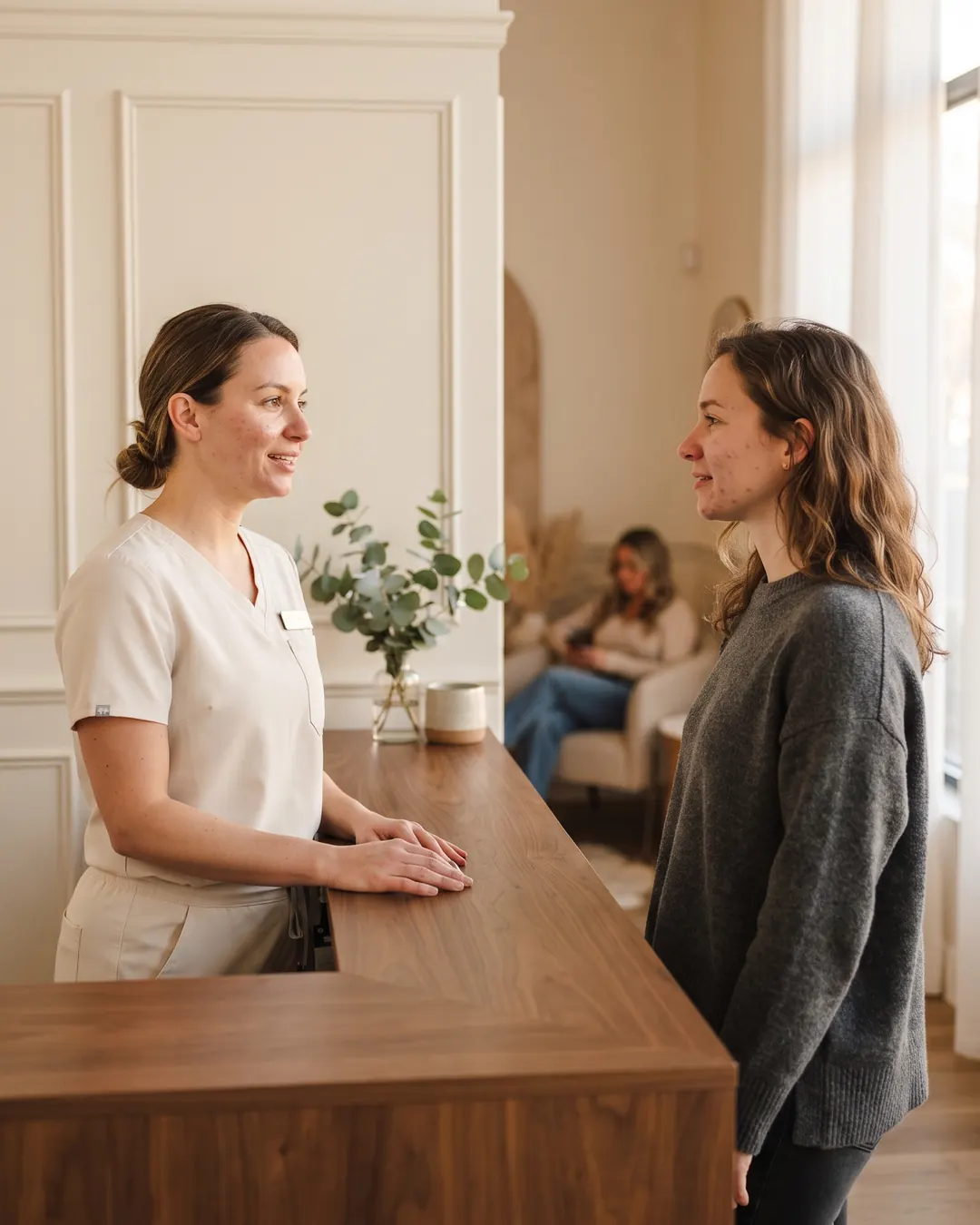 A busy med spa front desk with a coordinator helping a patient
