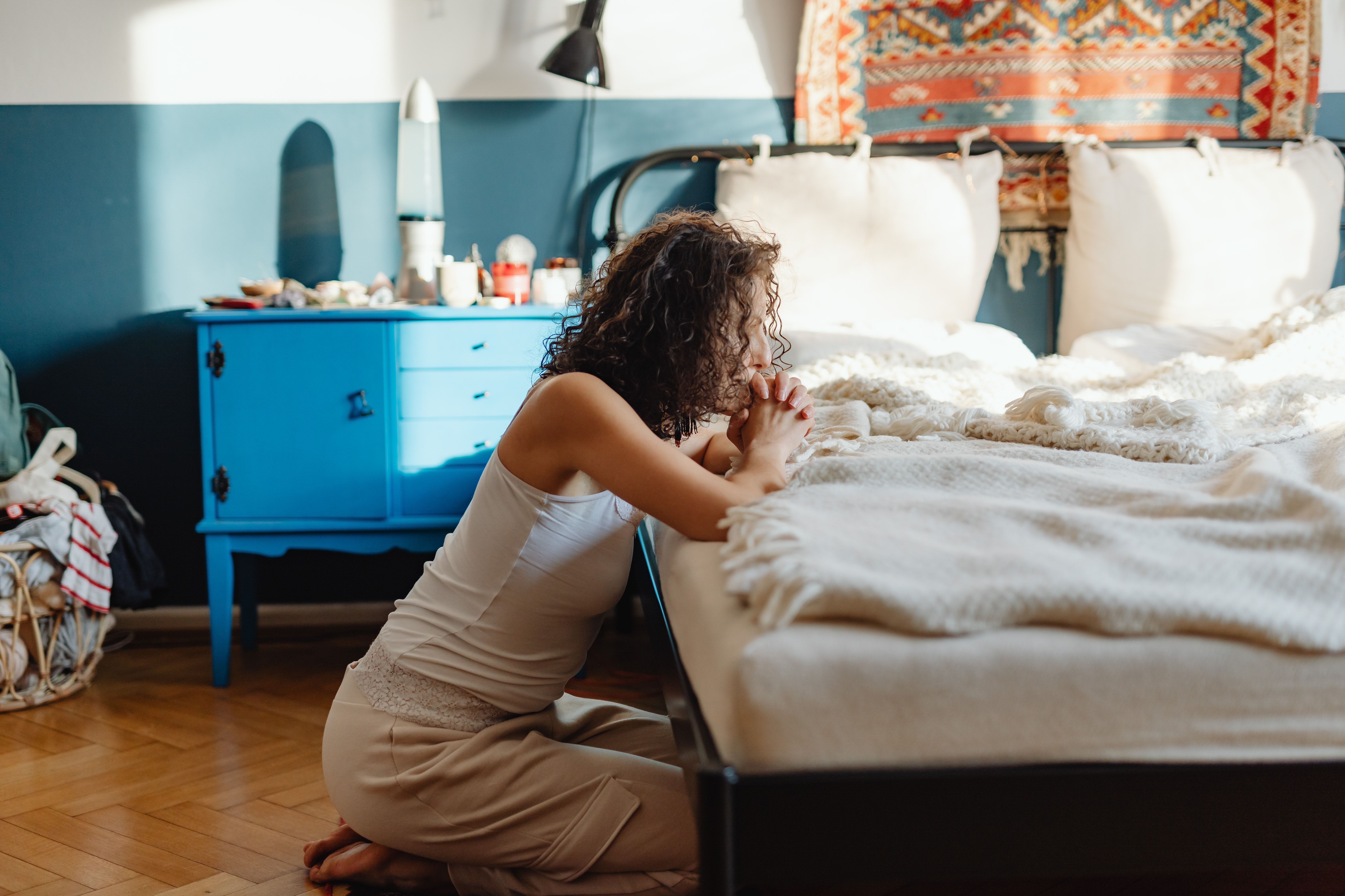 woman kneeling by bedside