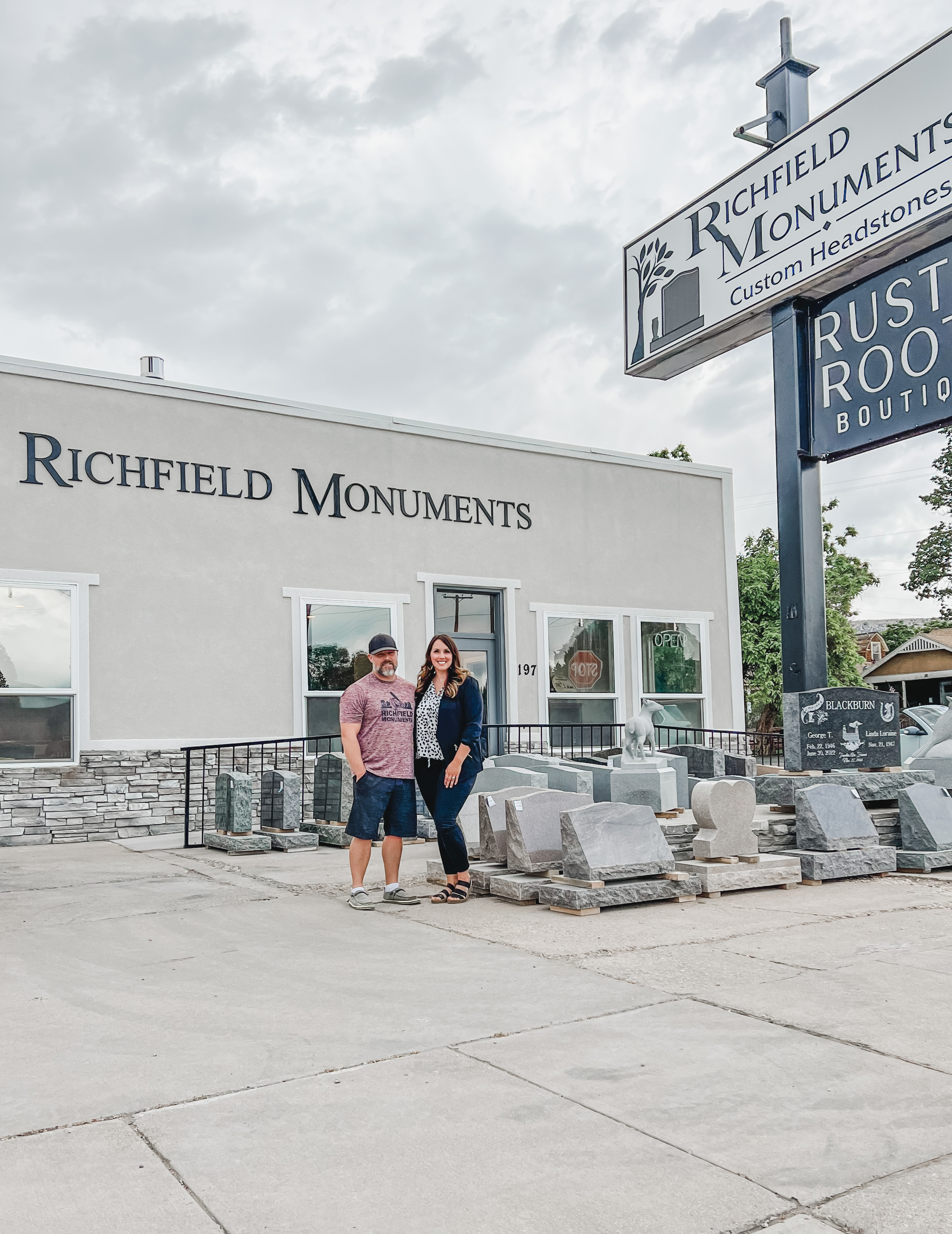 Owners of Richfield Monuments standing beside custom headstones, showcasing their craftsmanship in Richfield, Utah