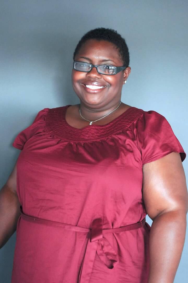 Rafat Fields wearing glasses and a short-sleeved burgundy dress stands smiling in front of a plain gray background. This photo was taken before her gastric bypass surgery. Rafat Fields wearing glasses and a short-sleeved burgundy dress stands smiling in front of a plain gray background. This photo was taken before her gastric bypass surgery.