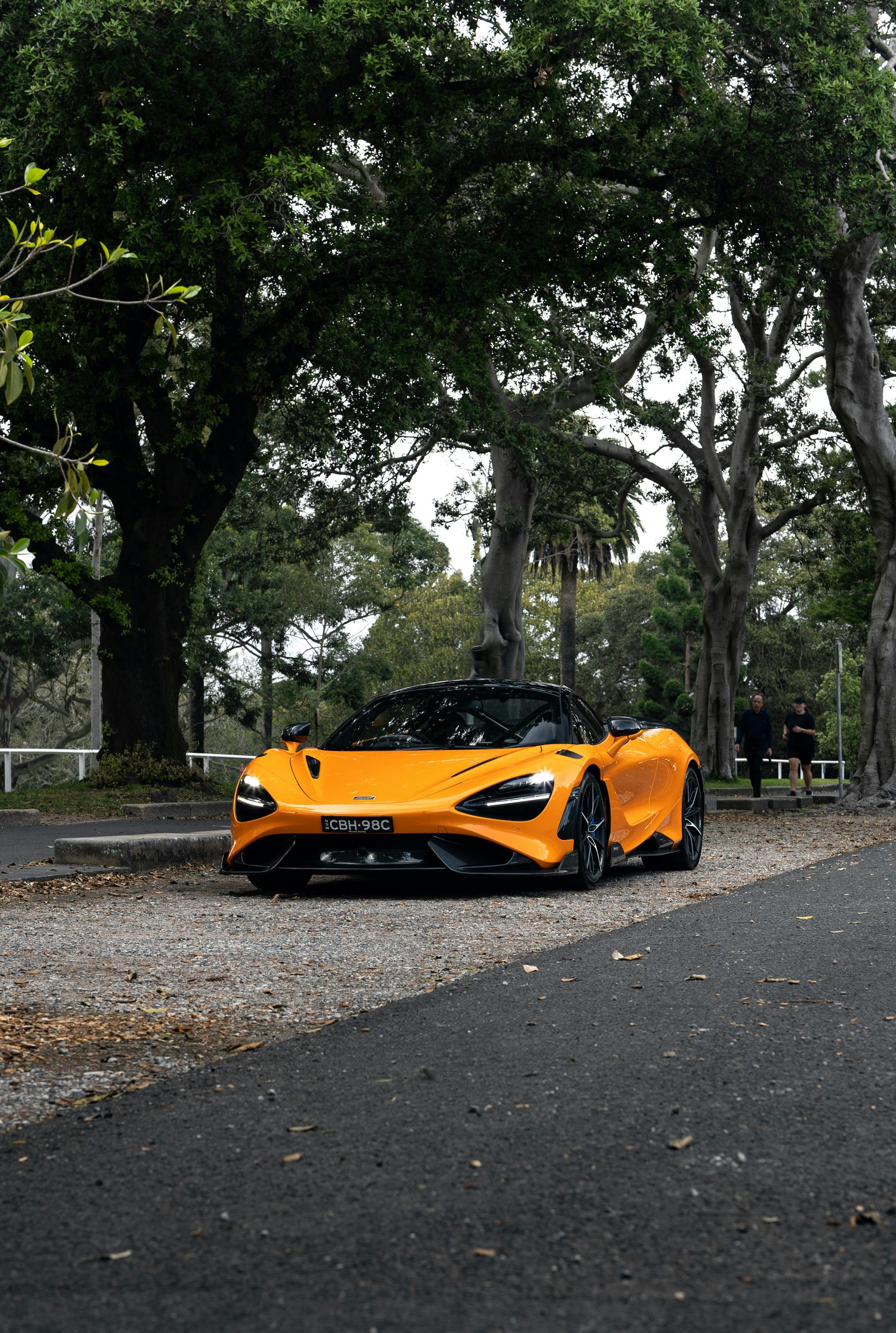 Orange McLaren supercar parked under trees after premium mobile detailing in Houston