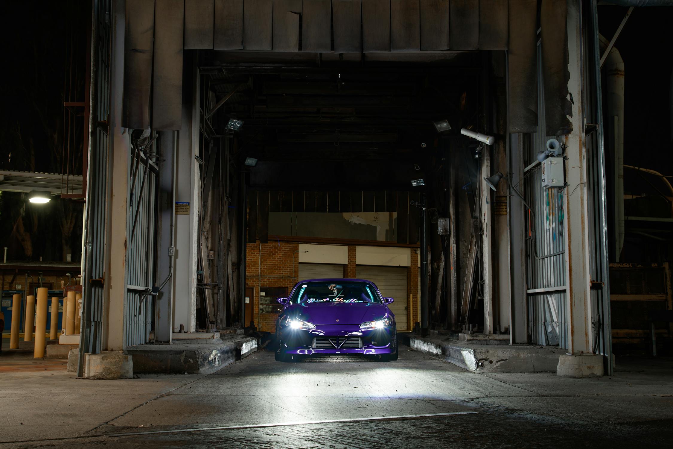 Exotic purple sports car under mobile detailing bay lights in Houston, Texas