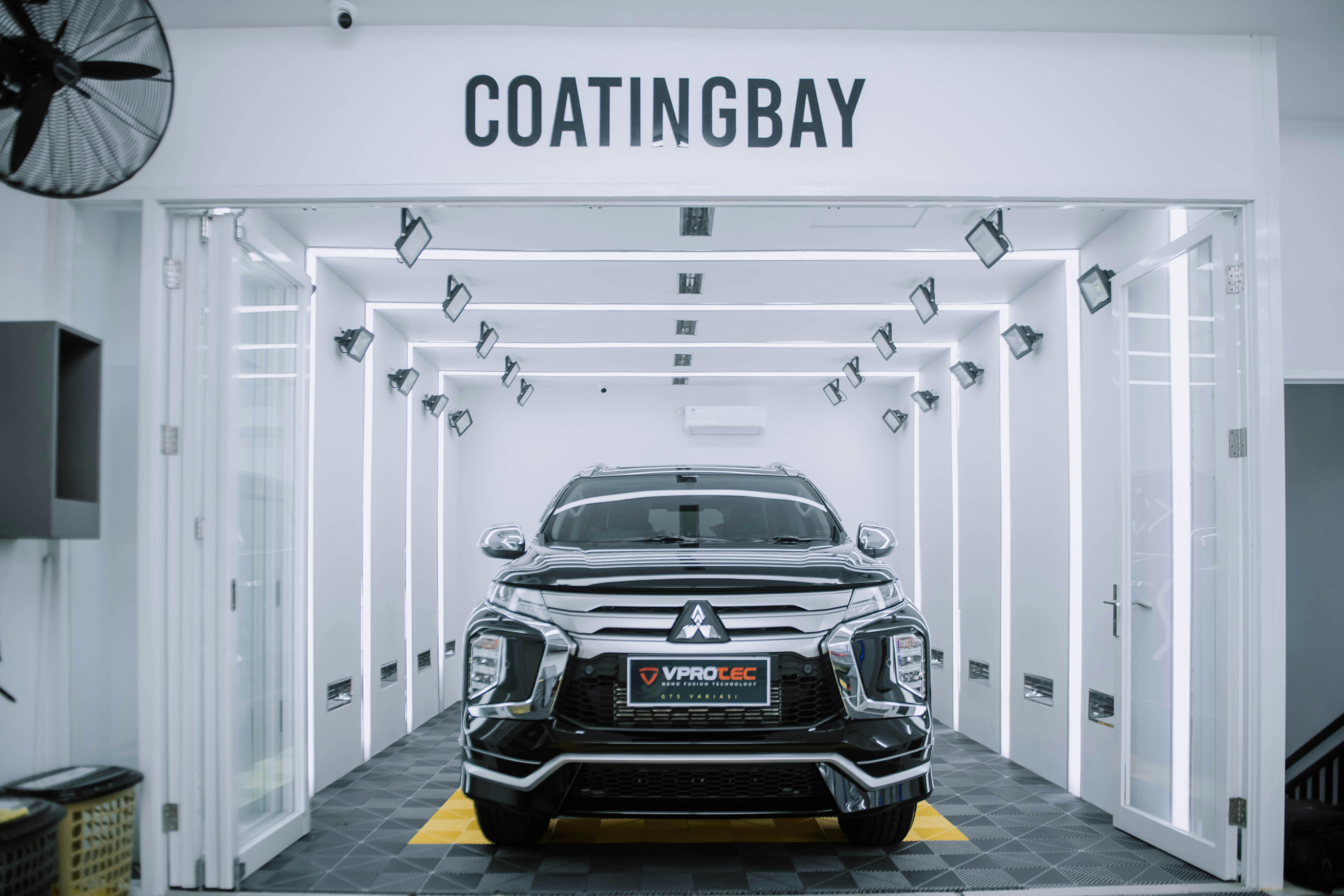 Black SUV in a professional coating bay ready for 9H ceramic application in Houston