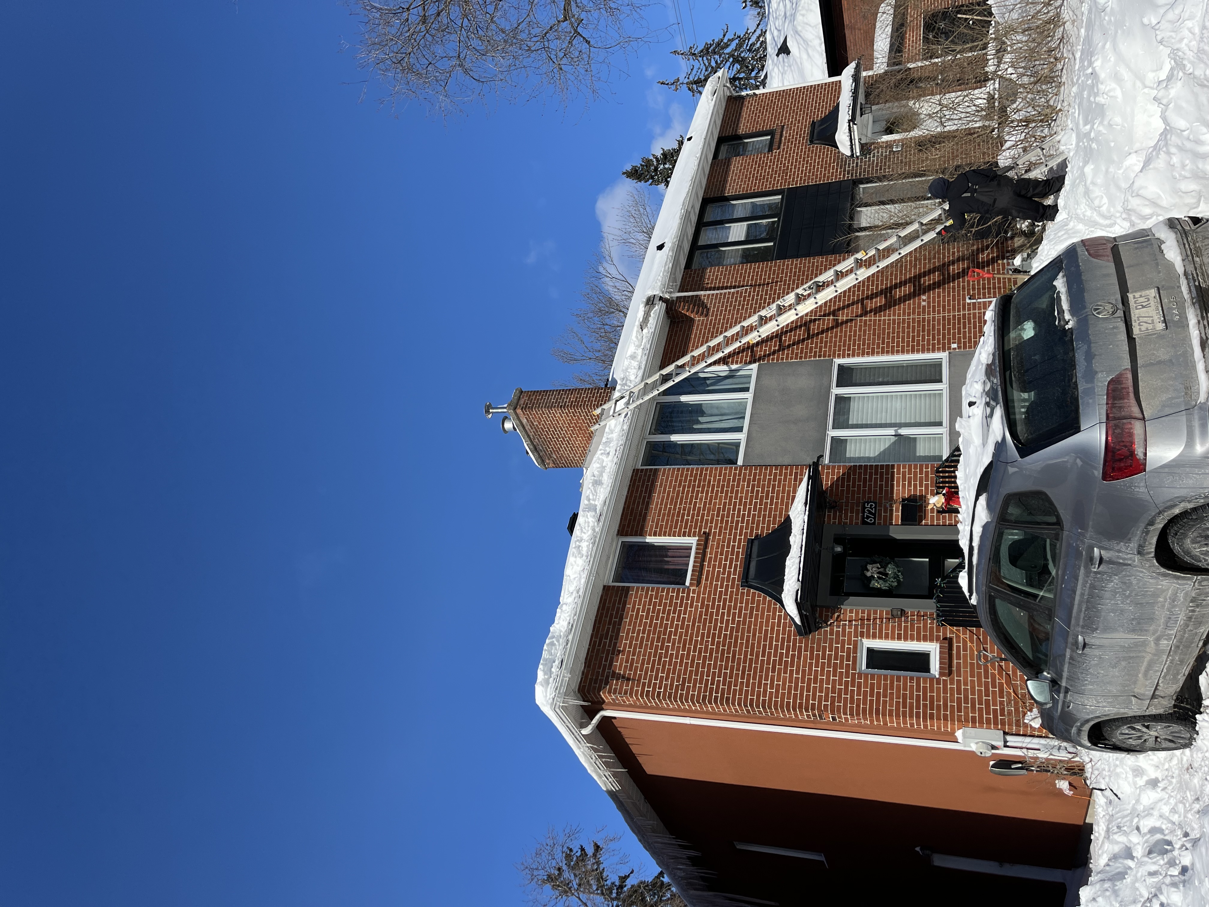 Techniciens enlevant la neige du toit et faisant fondre les digues de glace à la vapeur en toute sécurité