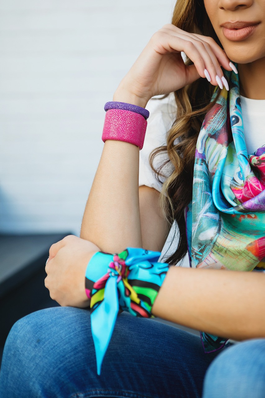Display of colorful Silkies from RoKi Design with examples of ways to wear the scarves and info on their charitable mission Display of colorful Silkies from RoKi Design with examples of ways to wear the scarves and info on their charitable mission