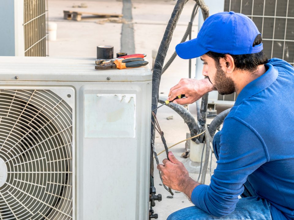 HVAC technician working on air conditioner