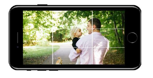 Phone with photo of father and daughter on screen. Rule of Thirds grid displayed. 5 photography phone tips