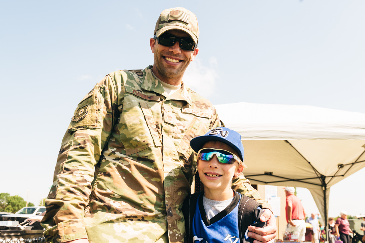 Military homecoming surprise video, father and son pose for camera.