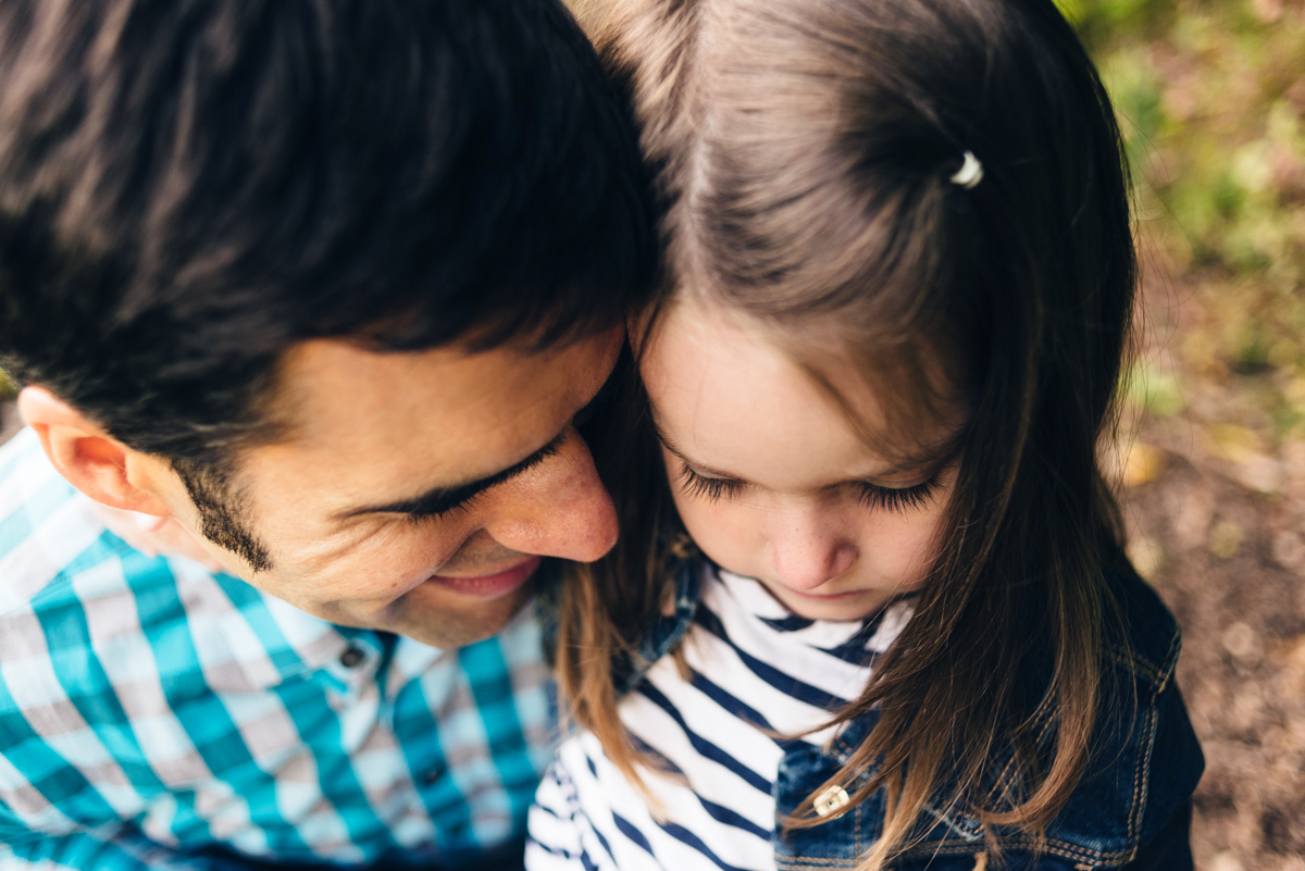 Father and daughter hug during sunset portrait photography session.