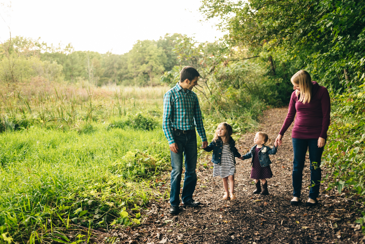 during sunset portrait photography session; family holding hands and walking.