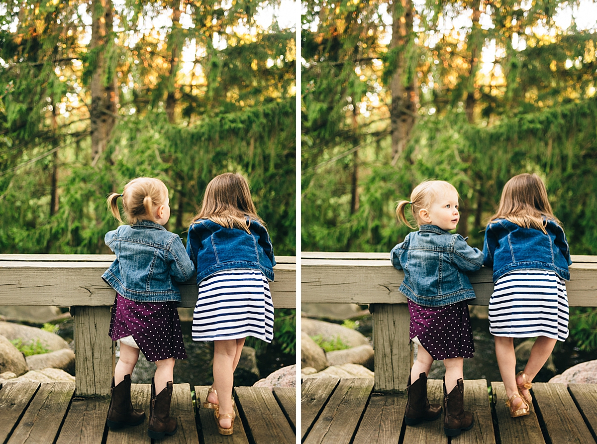 Kid sisters stand on a bridge and look out at the water at MN Landscape Arboretum during sunset portraits.