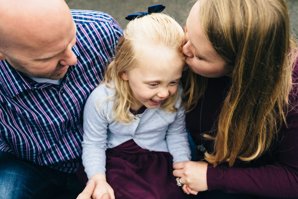 Session at Minnesota Landscape Arboretum. Mother kisses daughters forehead.