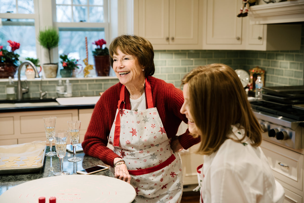 Grandmother and mother laughing in extended family cookie baking day.