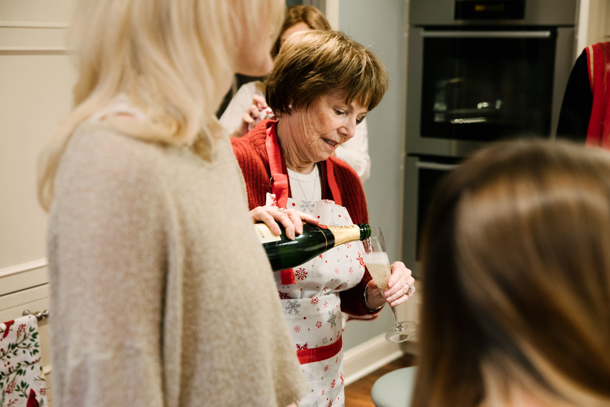 Grandmother pours a glass of champagne.