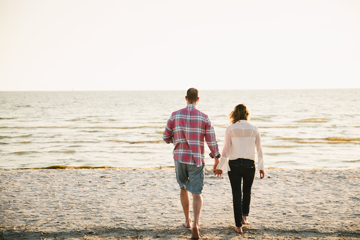 Couple walks toward Fort Myers Beach. Traveling family photographer.