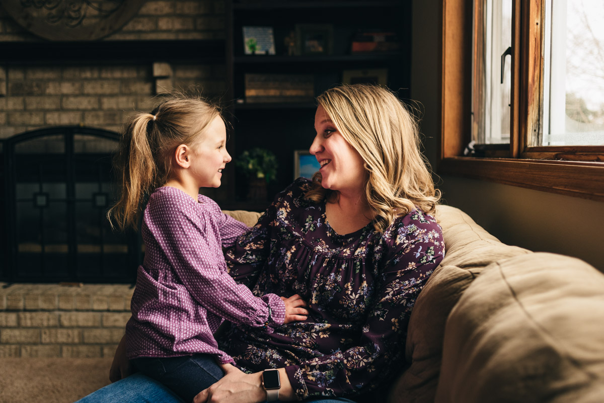 Mother and daughter talking on the couch.