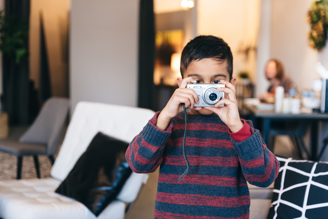 Little boy with camera takes photos.