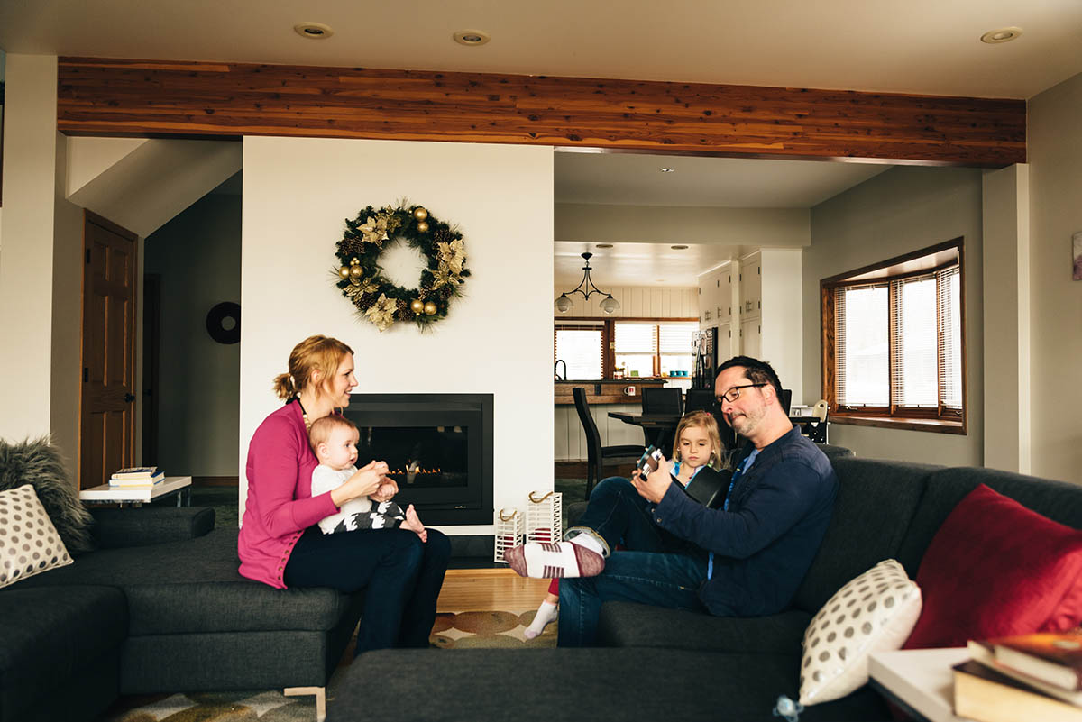 A family of four playing music on a couch during their Minnesota family video story session.