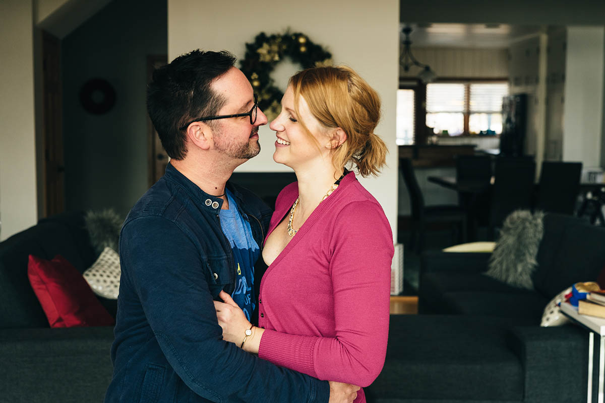 Couple stands close to each other smiling.