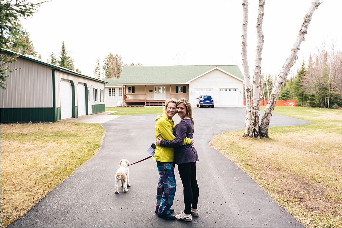 Mother and daughter stand in driveway of home they are selling in Father's Day tribute photos.