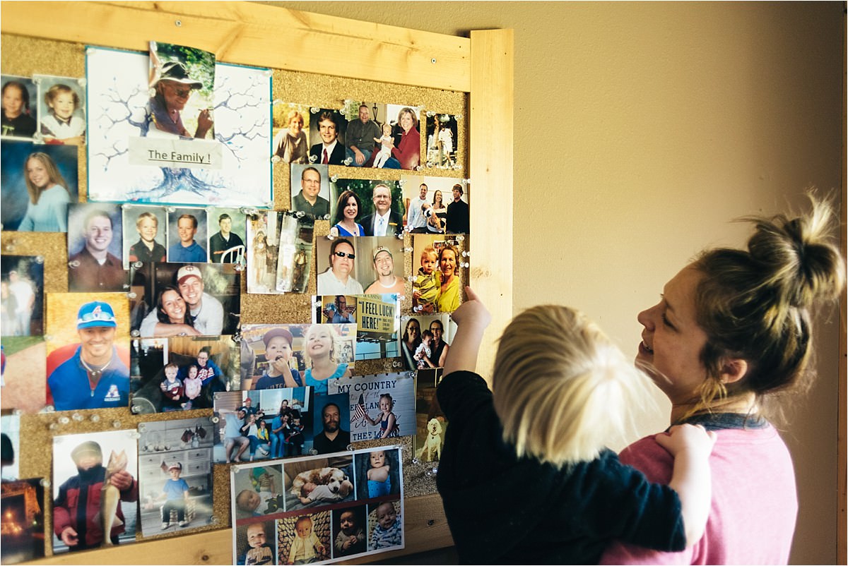 Mother and son look at board with tacked photos.