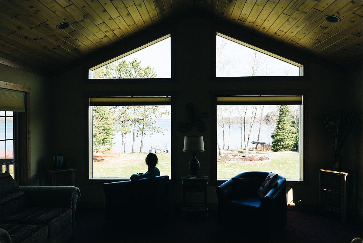 Silhouette of woman sitting in a chair near a window.