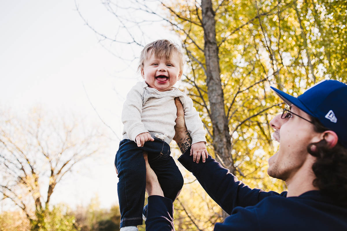 Father lifts son into the air.