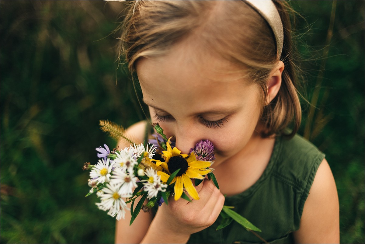 Young girl smells flowers.