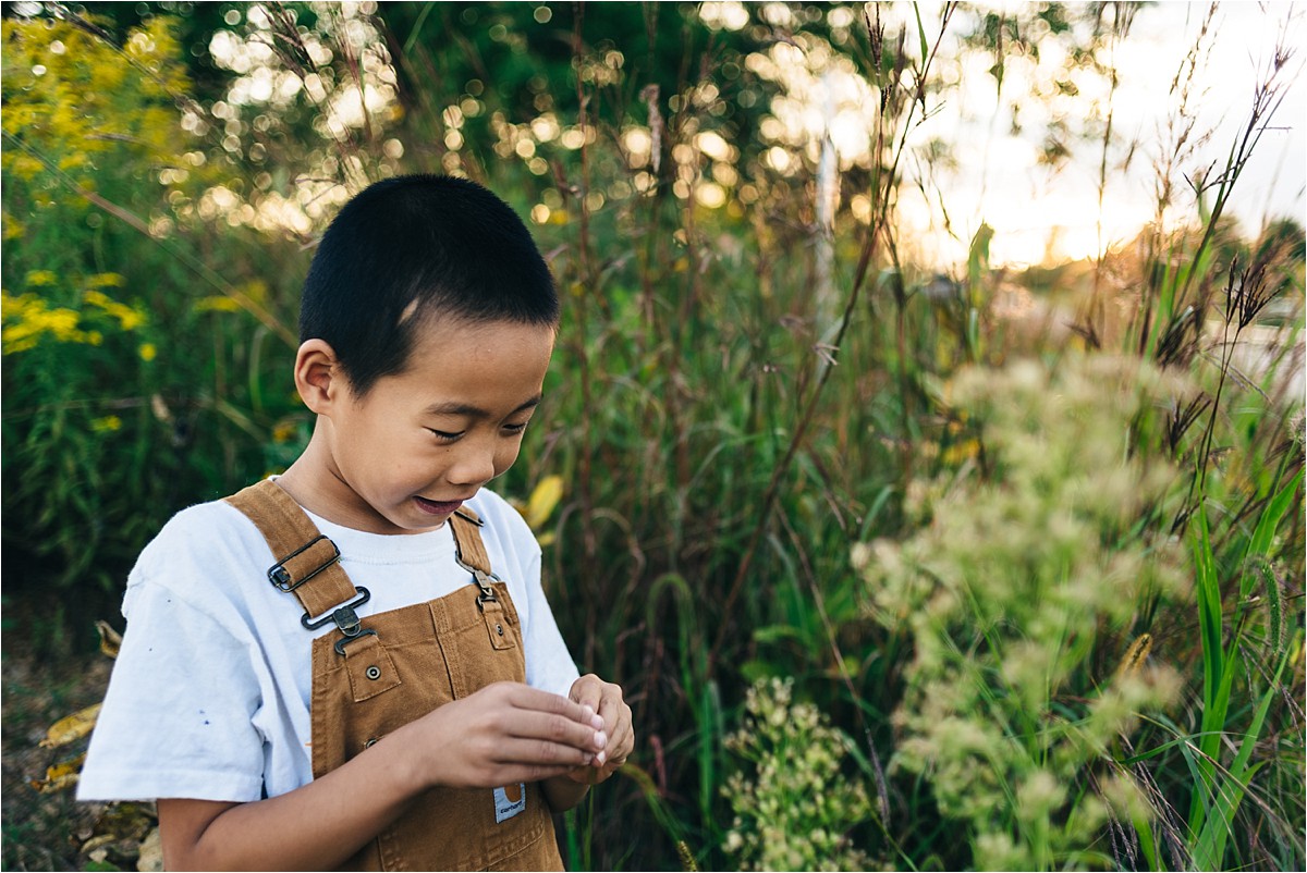 Boy finds cat tails near pond at Bea Hive Farm. photography