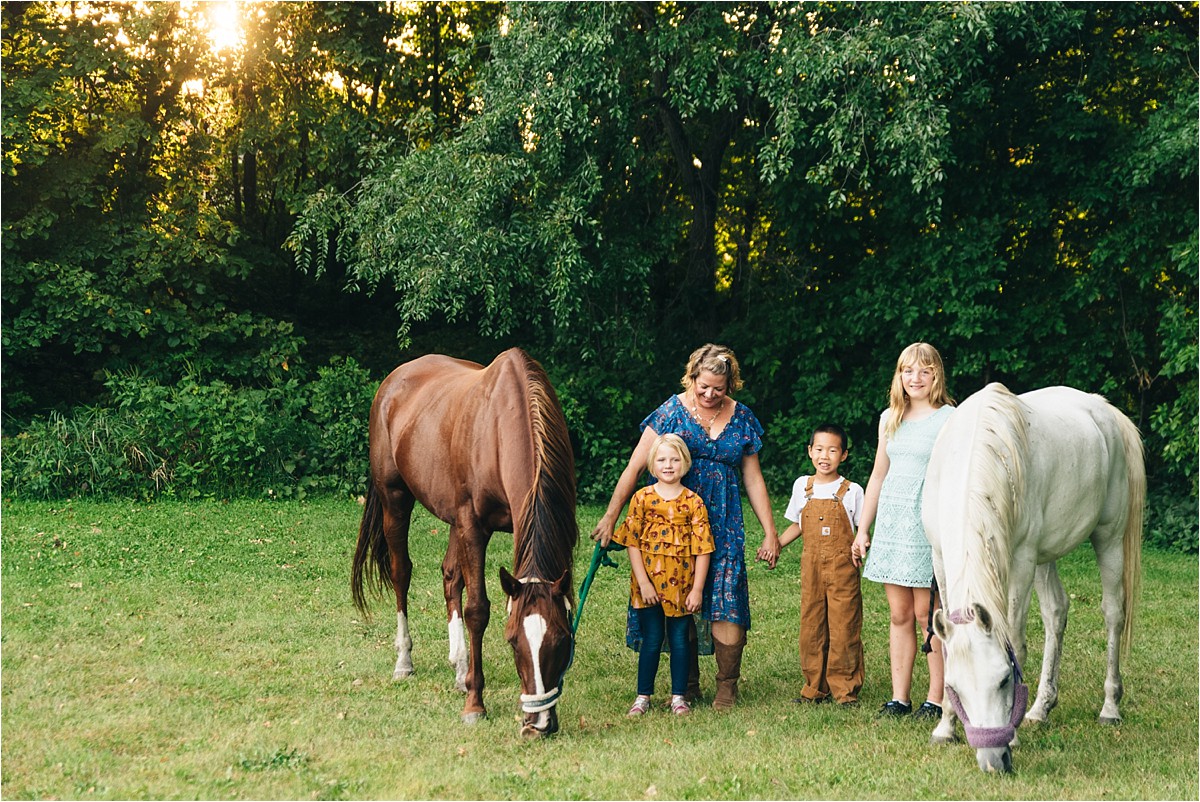 Woman and three kids hold reins of horses. Where to print photos.