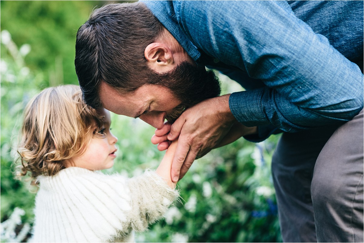 Father kisses daughters hurt hand to make it better.