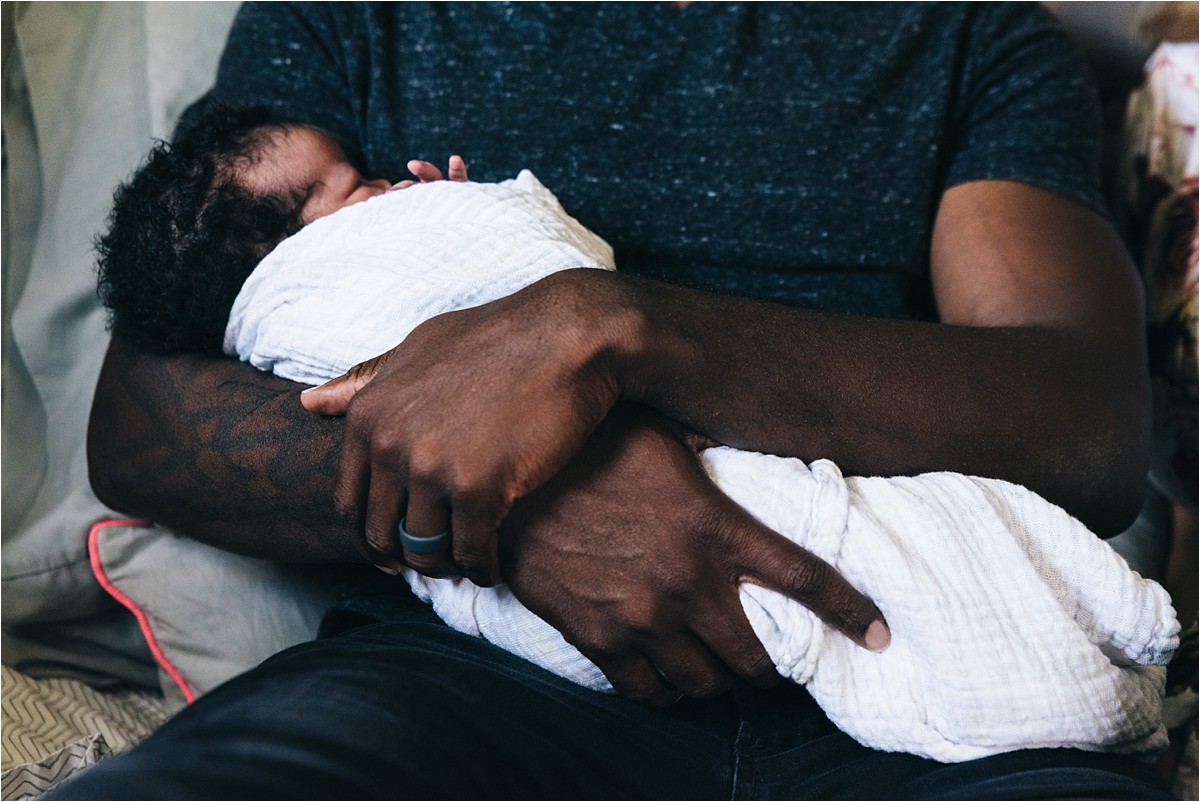 Father's arms with newborn daughter.