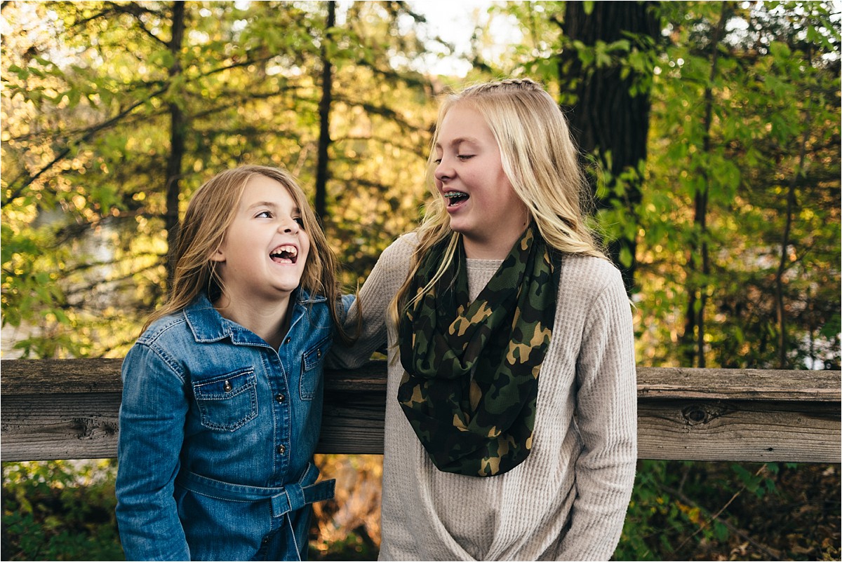 Two sisters looking at each other, giggling. 