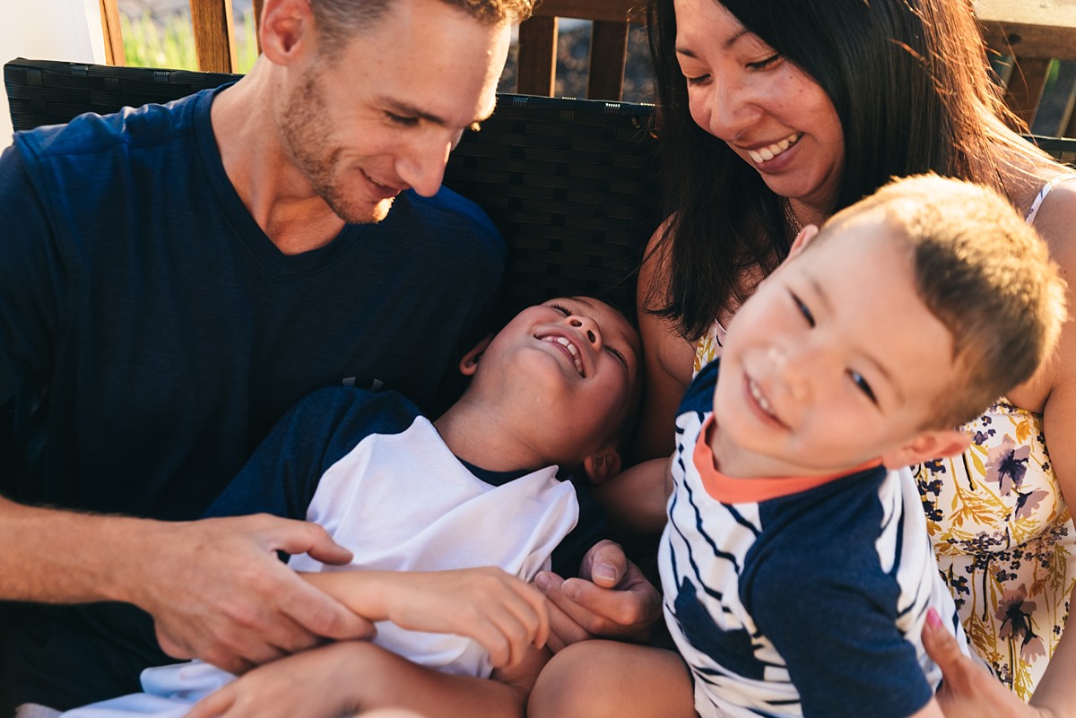 Family of four tickles each other.