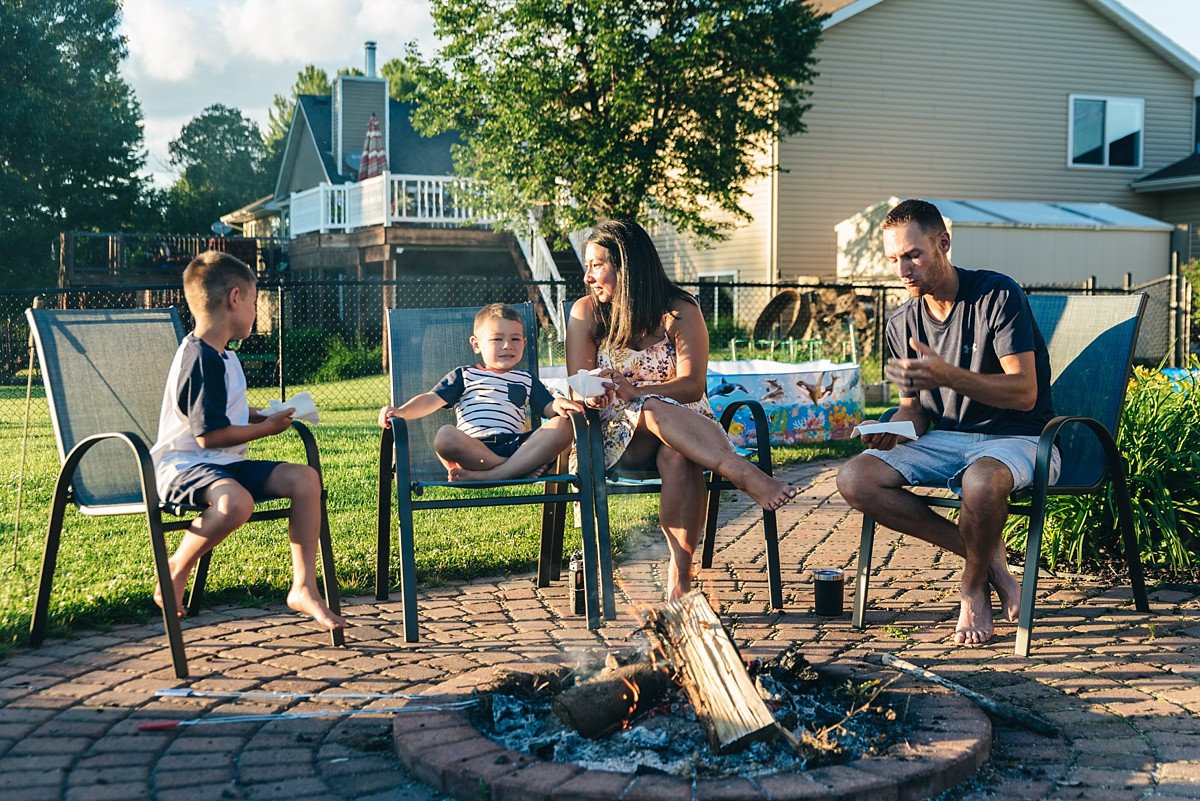 Family shares smores around a fire.