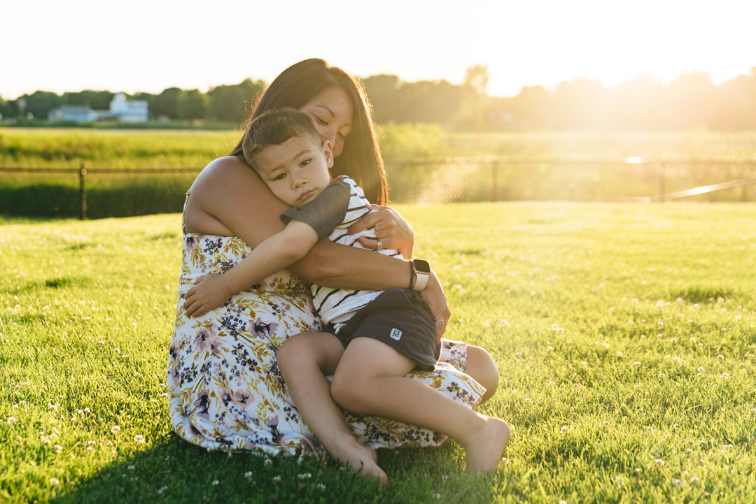 Boy hugs his mother in Hugo, MN backyard.