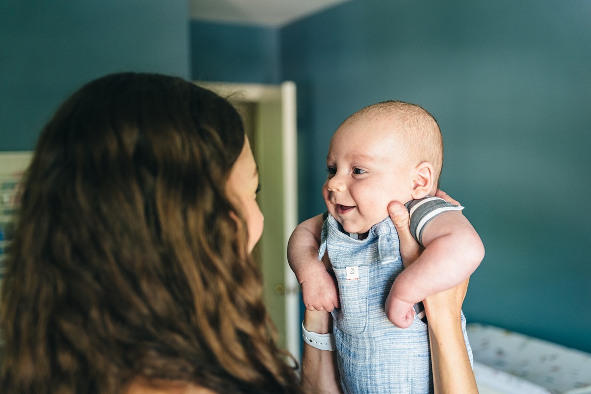 Baby boy in the arms of his mother during a full family film session.