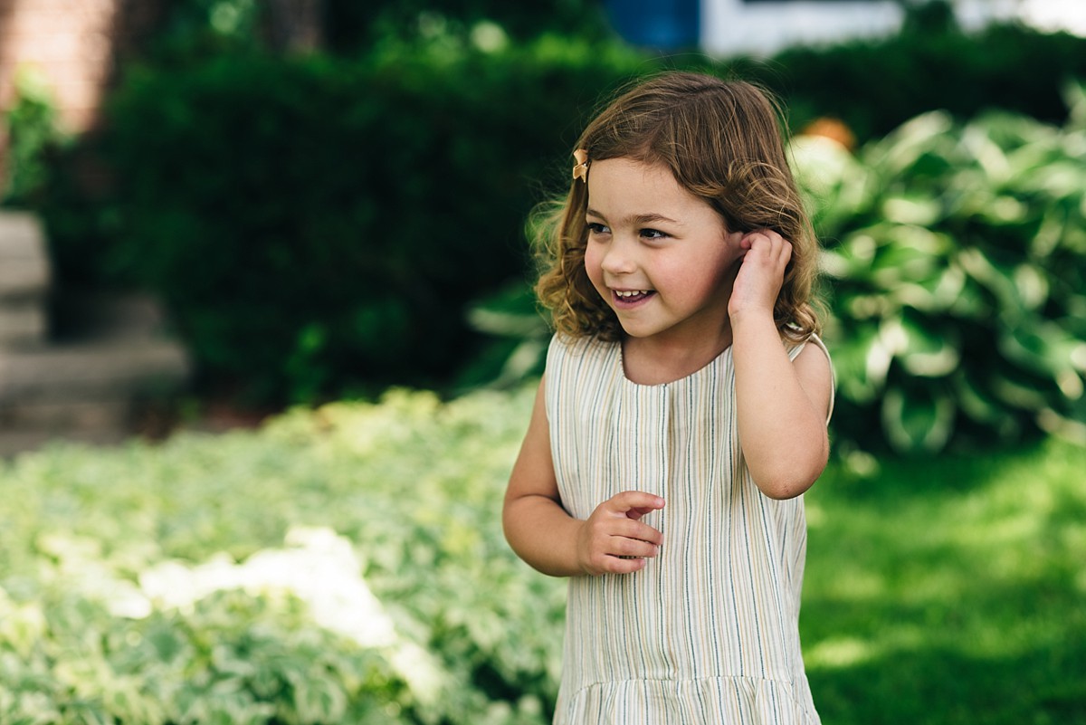 Little girl tucks hair behind ears.